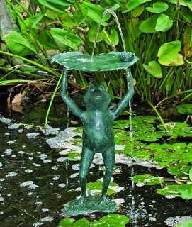 this bronze frog is lifting a lily pad and water cascades off the top 